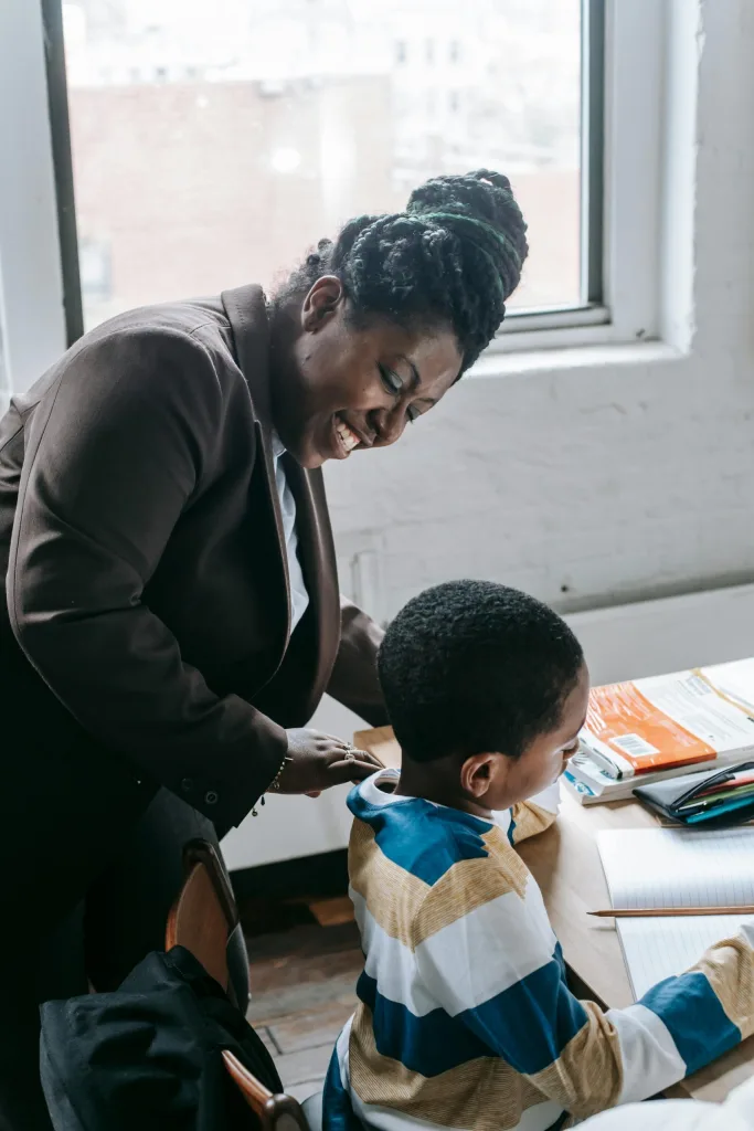 Black teacher smiling at black student