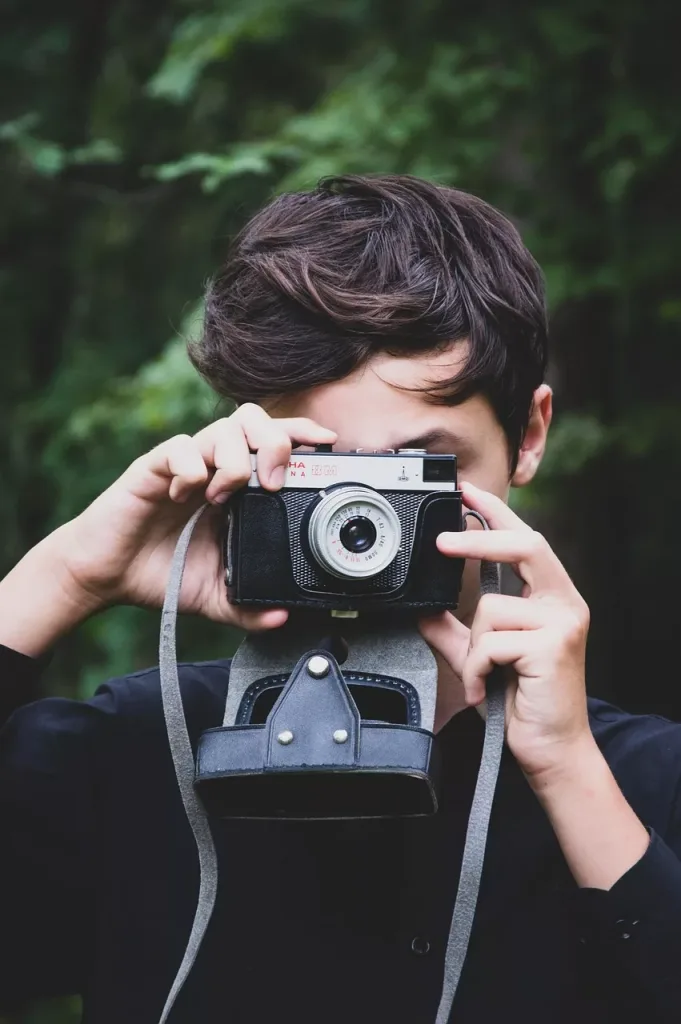 Man taking holding camera to face
