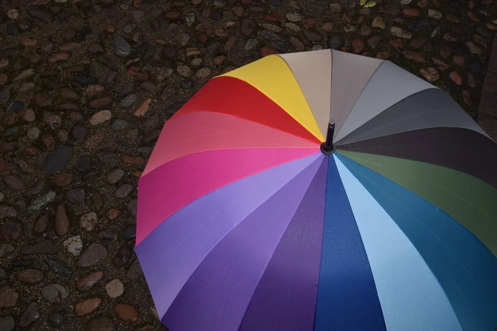 Colourful umbrella opened over pebbles