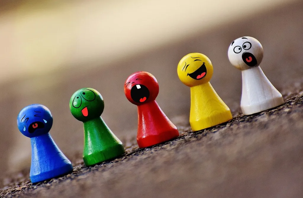 Multi-coloured pegs on the floor with different facial expressions