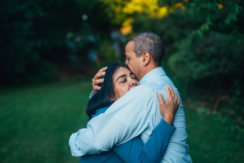 gus-moretta-BCyfpZE3aVE-unsplash Couple embracing in a hug in a green forest area