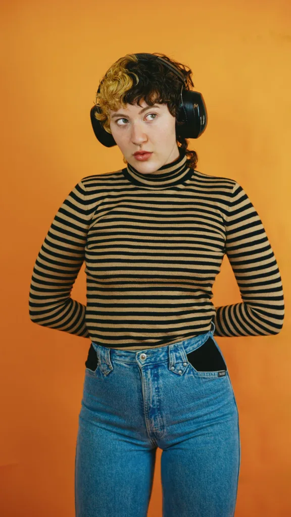Person with striped top and headphones on looking to the side