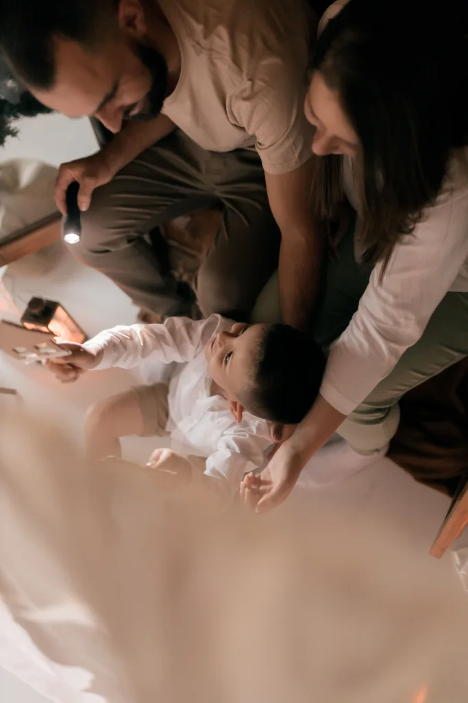 Family holding child with a flash light