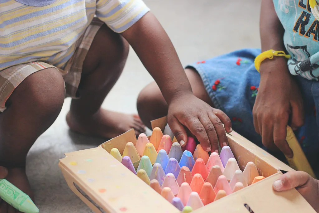Young children playing with coloured chalks